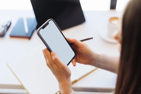 Mãos de mulher segurando um smartphone com tela em branco — Fotografia de Stock