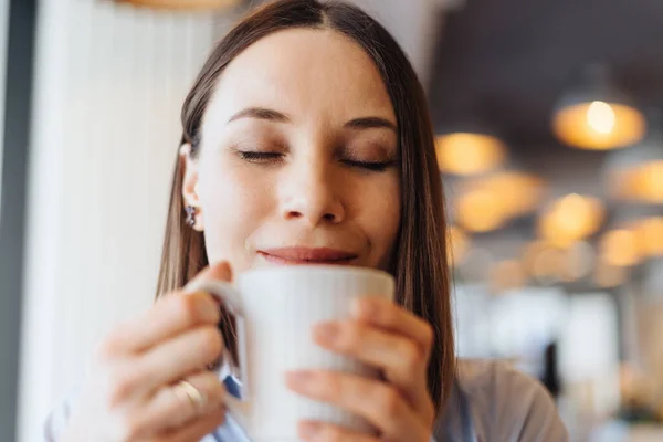 Πορτρέτο της νεαρής γυναίκας πίνοντας καφέ στο τραπέζι στο καφέ — Φωτογραφία Αρχείου