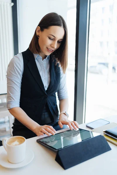 Portrait de jeune femme buvant du café à table avec tablette dans un café — Photo