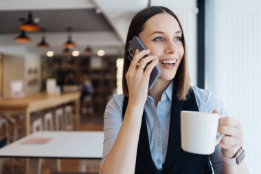 Kafkasyalı güzel bir kadın iş için akıllı telefon kullanıyor.