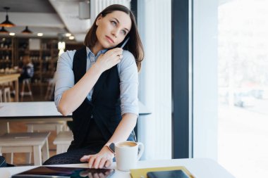 Kafkasyalı güzel bir kadın iş için akıllı telefon kullanıyor.