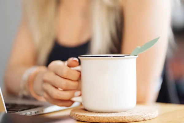 Close-up vrouw hand het houden van een mok thee thuis — Stockfoto