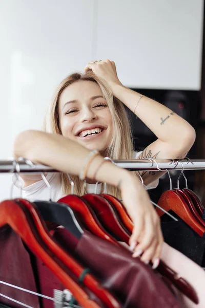 Mooie jonge vrouw kiezen kleding op grote verkoop — Stockfoto