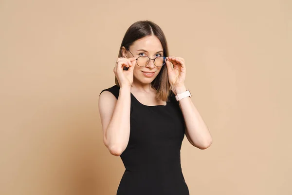 Ritratto di una giovane donna d'affari con occhiali su sfondo beige — Foto Stock