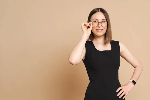 Retrato de una joven mujer de negocios con gafas sobre fondo beige — Foto de Stock