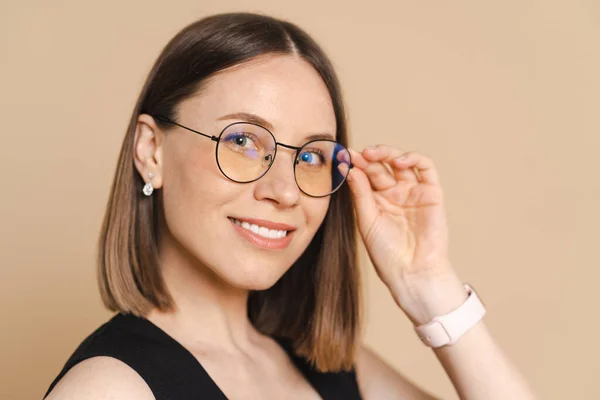 Retrato de una joven mujer de negocios con gafas sobre fondo beige — Foto de Stock