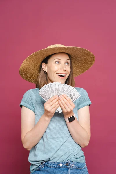 Smiling Young woman holding money on pink background — Stock Photo, Image