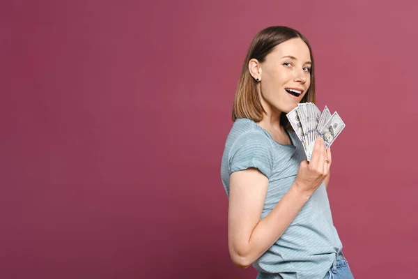 Happy woman holding dollars on pink background Royalty Free Stock Photos