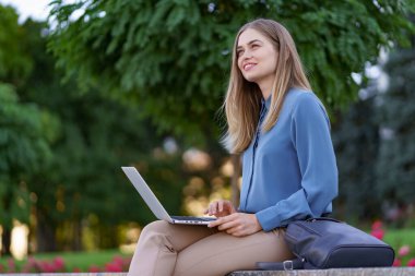 Şehir meydanında dizüstü bilgisayarda çalışan genç kadınlar