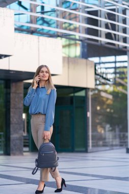 BACKpack 'li MODERN KADINLAR İŞ BÖLGESİ BÖLGESİNDE TELEFON EDİYOR