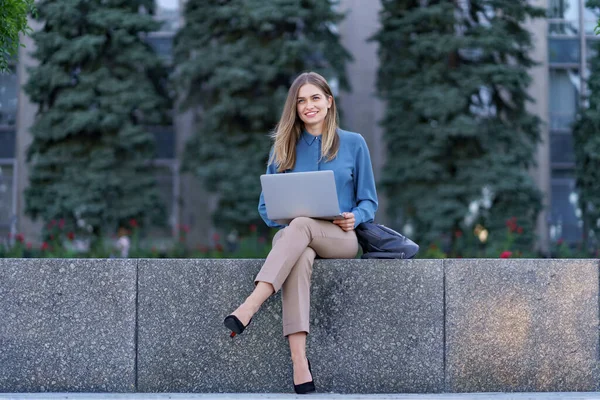 Young women working on laptop in the city square — Stock Photo, Image