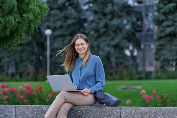 Young women working on laptop in the city square — Stock Photo, Image