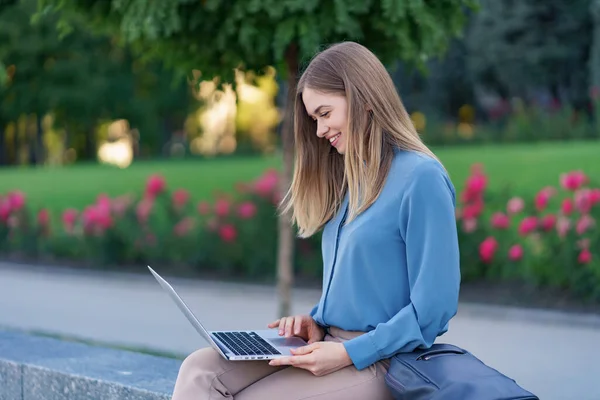 Young women working on laptop in the city square — Stock Photo, Image