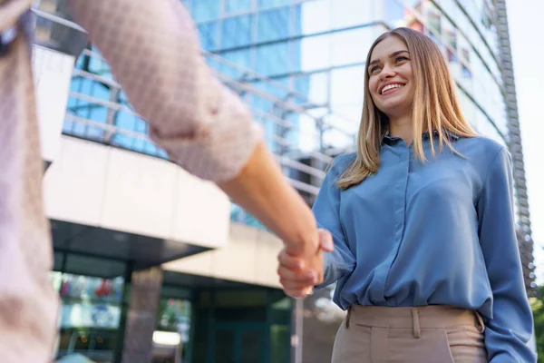 Las manos de mujer tiemblan sobre fondo de construcción empresarial — Foto de Stock