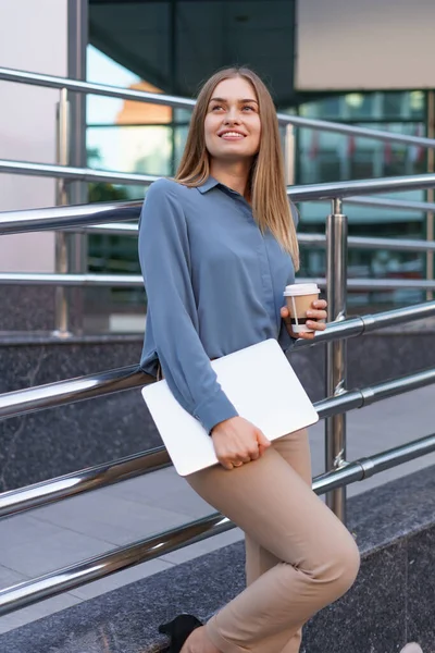 Retrato sonriente mujer sosteniendo portátil y café al aire libre — Foto de Stock