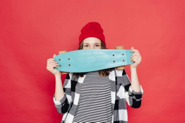 Kırmızı arka planda bozuk paralarla poz veren güzel bir genç.