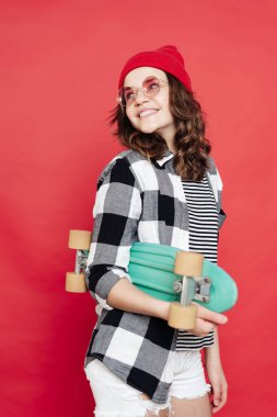 Kırmızı arka planda bozuk paralarla poz veren güzel bir genç.