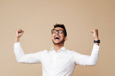 Afro genç adam zaferi bej arka planda kutluyor