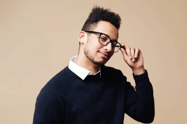 Afro bom cara olhando no preto suéter e óculos posando no bege fundo — Fotografia de Stock