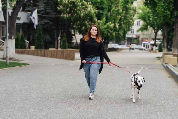 Kobieta spacerująca, dyskutująca i bawiąca się swoim dalmatyńskim zwierzakiem w mieście — Zdjęcie stockowe