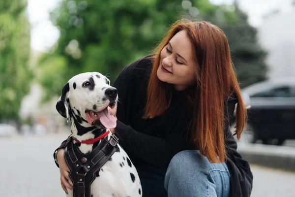 可愛いです女性ポーズと巨大ダルマチア犬上の街の背景 — ストック写真