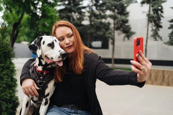 若いです女性取るaセルフィーとともに携帯電話とともに彼女の犬で街. — ストック写真