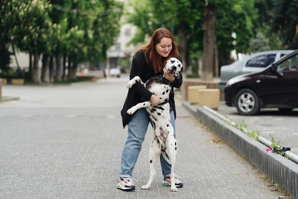 Kobieta dyskutująca i szkoląca swojego dalmatyńskiego zwierzaka w mieście — Zdjęcie stockowe