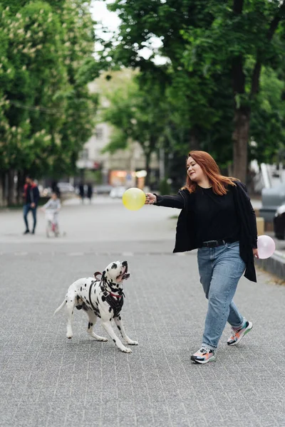 Kobieta dyskutująca i szkoląca swojego dalmatyńskiego zwierzaka w mieście — Zdjęcie stockowe