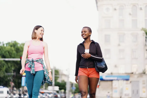 Two multiethnic girls walking for a exercise session, outdoor communicating. — Stock Photo, Image