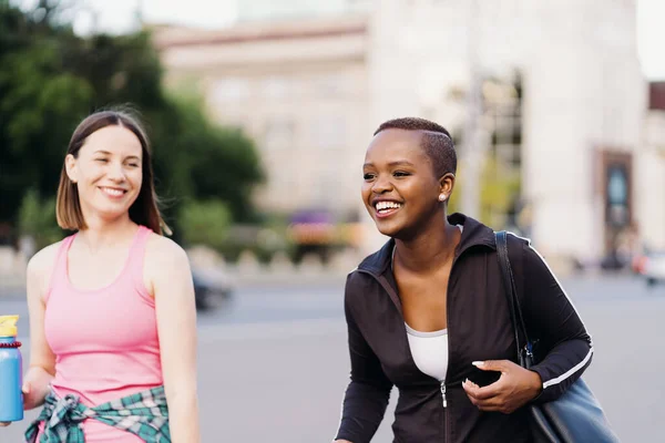 Two multiethnic girls walking for a exercise session, outdoor communicating. — Stock Photo, Image