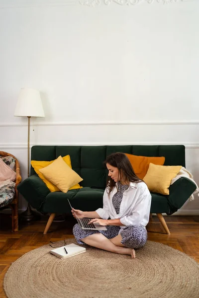 Affärskvinna som arbetar på bärbar dator sitter hemma och sköter sitt företag via hemmakontoret — Stockfoto