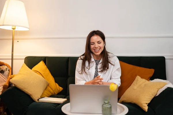 Affärskvinna som arbetar på bärbar dator sitter hemma och sköter sitt företag via hemmakontoret — Stockfoto