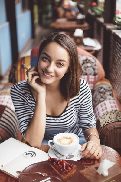 Junge Frau sitzt drinnen in urbanem Café — Stockfoto