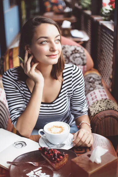 Jonge vrouw zitten binnen in stedelijke café — Stockfoto