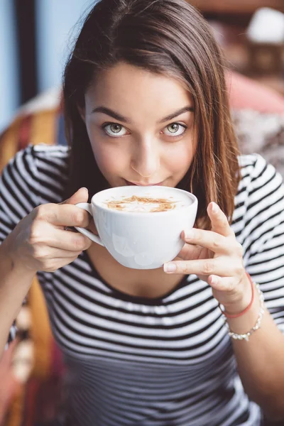 Młoda kobieta picia kawy w kawiarni miejskiej — Stockfoto