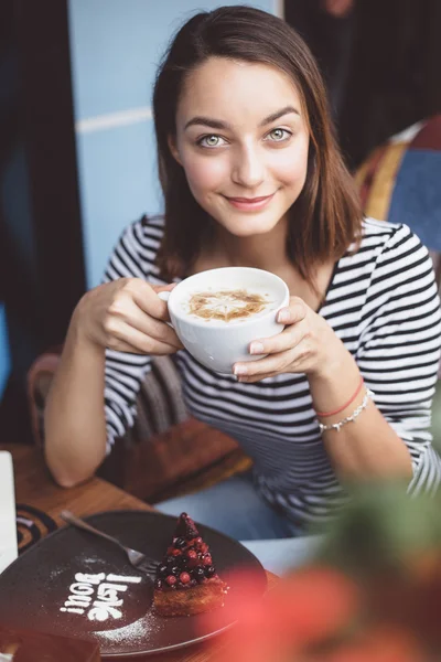 Młoda kobieta picia kawy w kawiarni miejskiej — Stockfoto