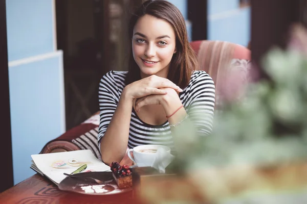 Młoda kobieta picia kawy w kawiarni miejskiej — Stockfoto