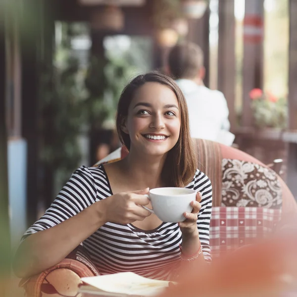 Jeune femme buvant du café dans un café urbain — Photo