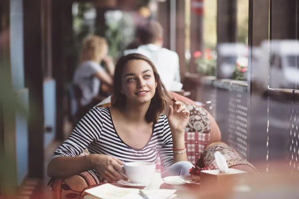 Jovem mulher bebendo café no café urbano — Fotografia de Stock