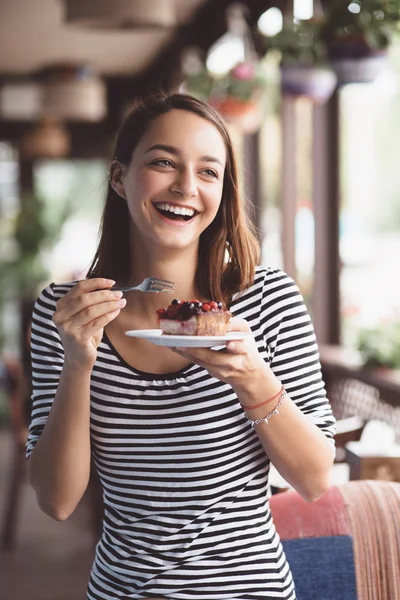 Jonge vrouw eten strawberry cheesecake — Stockfoto