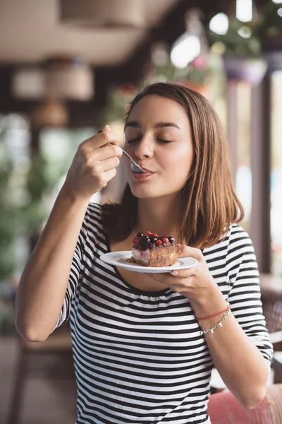 Jonge vrouw eten strawberry cheesecake — Stockfoto