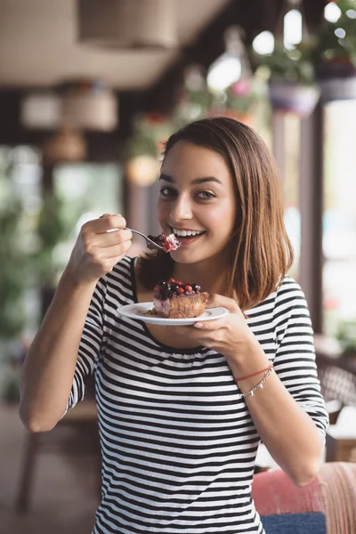 Junge Frau isst Erdbeerkäsekuchen — Stockfoto