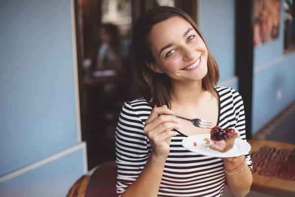 Mujer joven comiendo pastel de queso de fresa — Foto de Stock