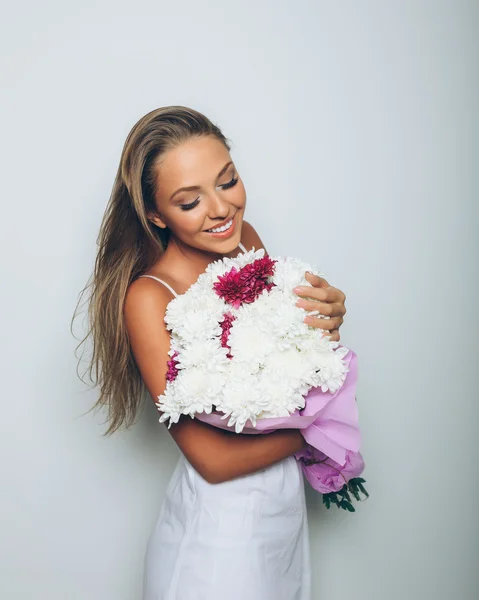 Mujer joven con ramo de flores sobre fondo blanco — Foto de Stock