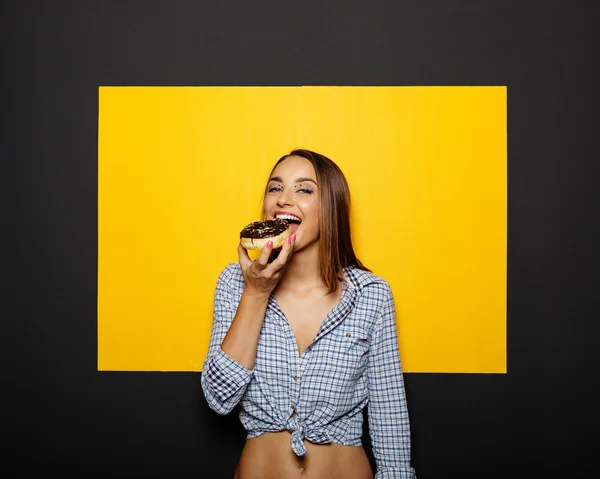 Chica comiendo donut con hielo de chocolate — Foto de Stock