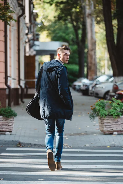 Un jeune homme traverse la rue — Photo