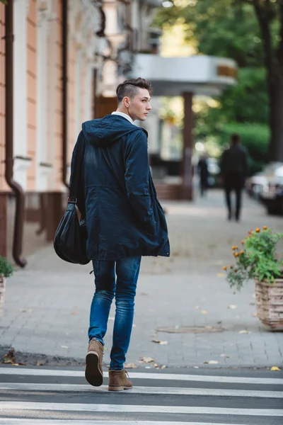 Un jeune homme traverse la rue — Photo