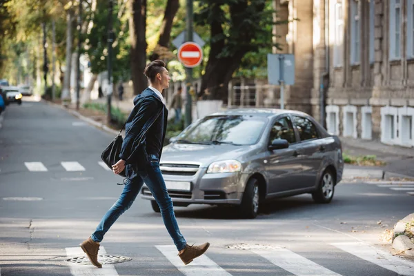 Un jeune homme traverse la rue — Photo