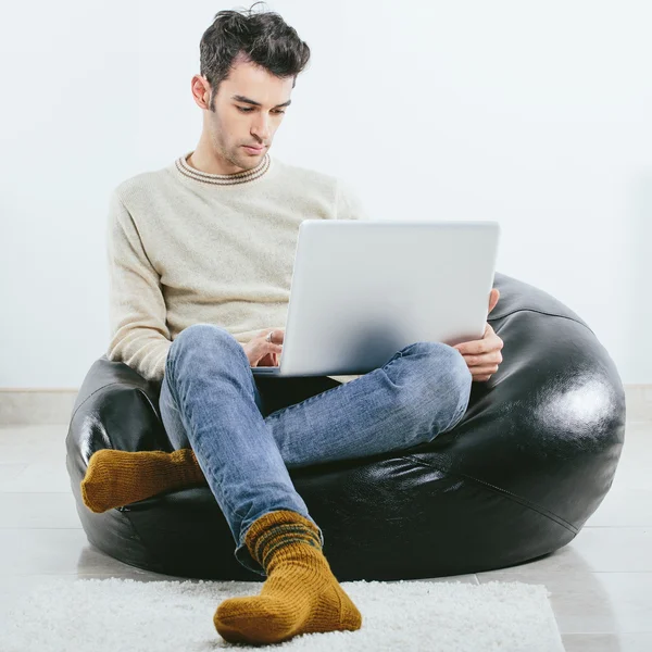 Uomo alla moda in inverno vestiti a maglia con computer portatile — Foto Stock