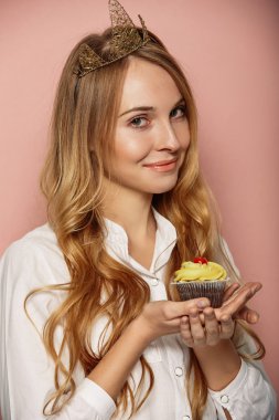 Çekici kız bir taç ve cupcake